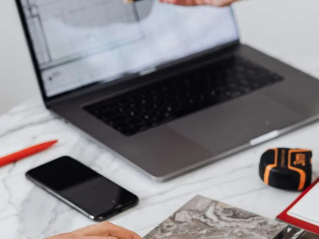 Lakberendező és megrendelő a tervkoncepciót és az anyagmintákat egyezteti laptop mellett